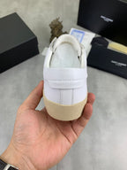 White low-top sneaker heel with strap tab and beige rubber sole