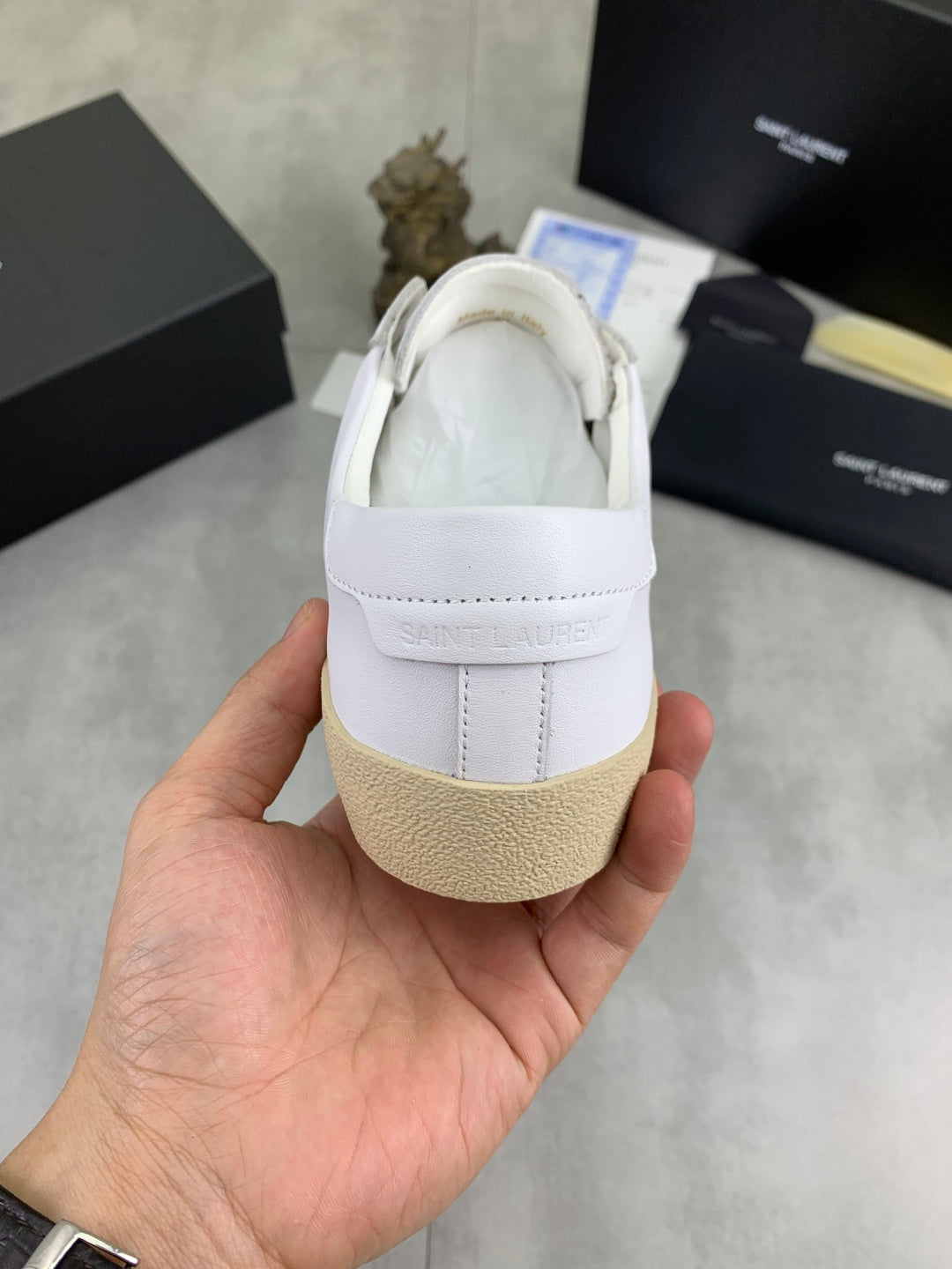 White low-top sneaker heel with strap tab and beige rubber sole