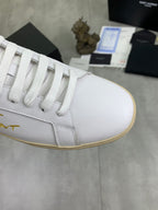 White sneaker upper close-up with lace eyelets and beige-edged cupsole