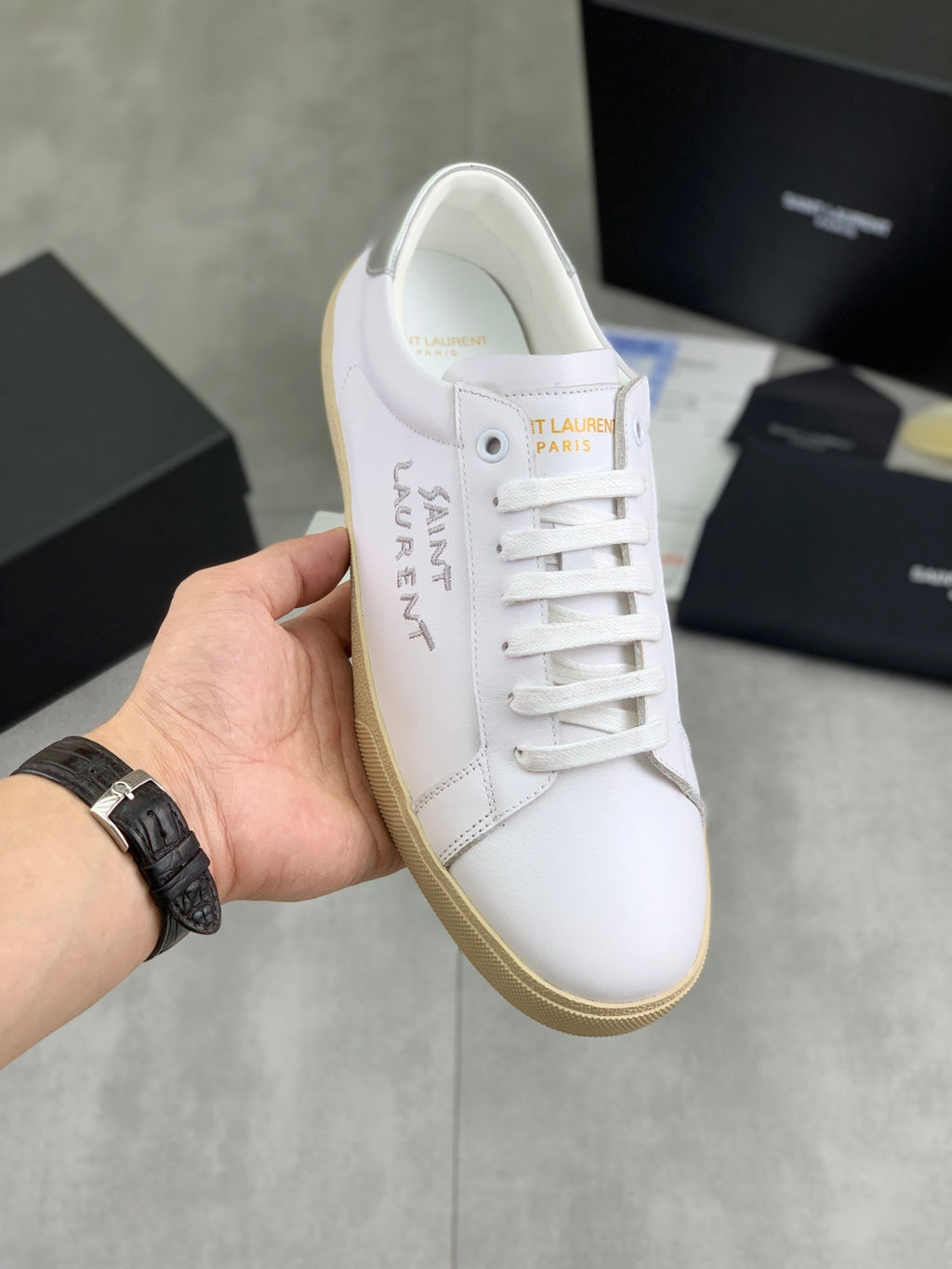 Luxury shoes, white leather look with white laces and beige rubber sole.