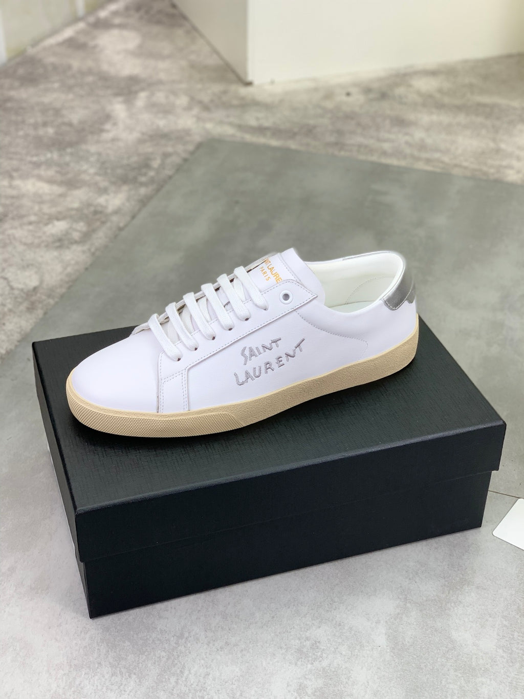 Luxury shoes, white lace-up sneakers with beige rubber sole.