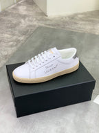 Luxury shoes, white lace-up sneakers with beige rubber sole.