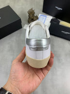 Luxury shoes heel view in white with beige sole and silver rear strap.