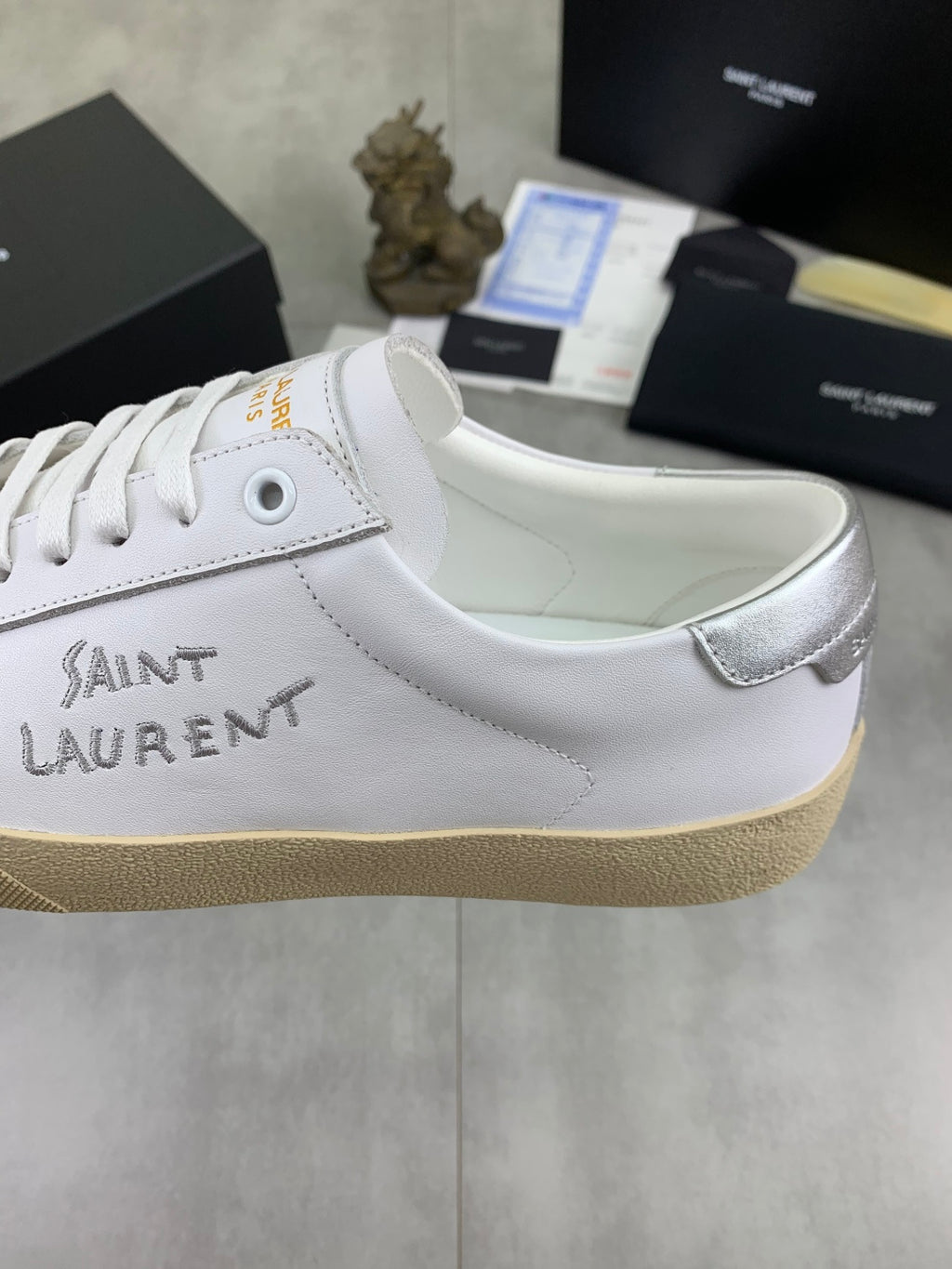 Luxury shoes with white leather upper, lace eyelets, and beige platform sole.
