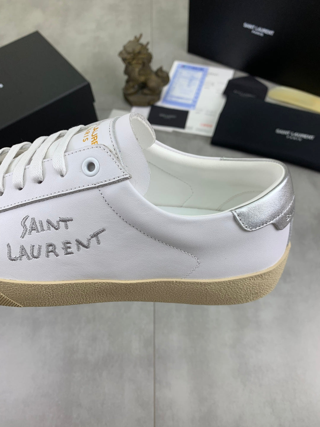 Luxury shoes with white leather upper, lace eyelets, and beige platform sole.