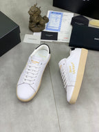 White low-top sneaker with gold side lettering and off-white rubber sole