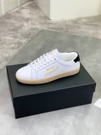 White low-top sneaker with gold side lettering and black heel tab