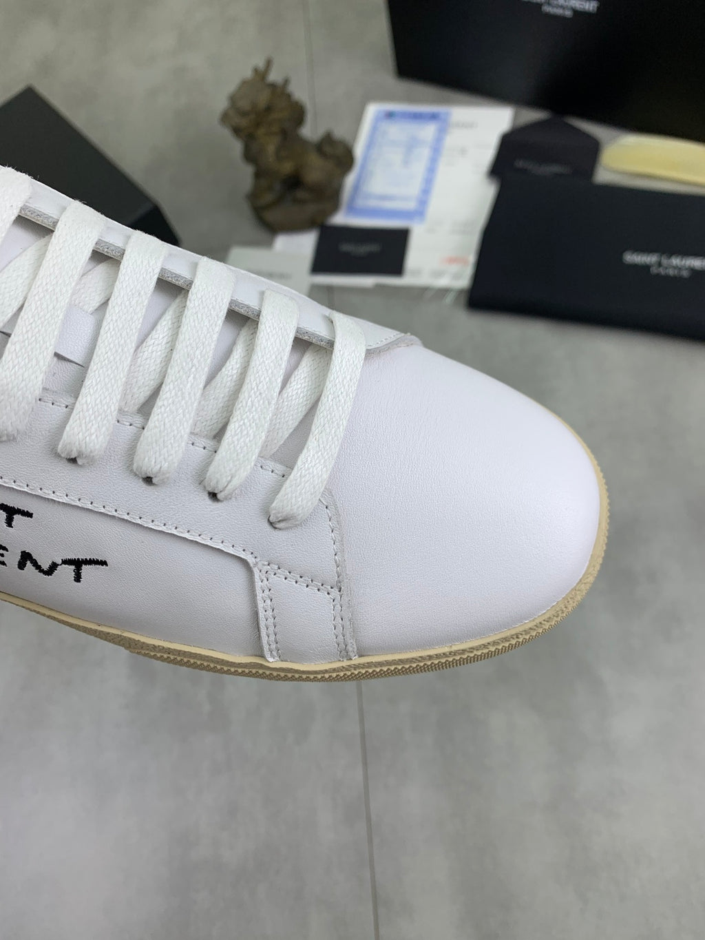 White YSL unisex sneaker upper close-up, white laces and gum-trim sole edge