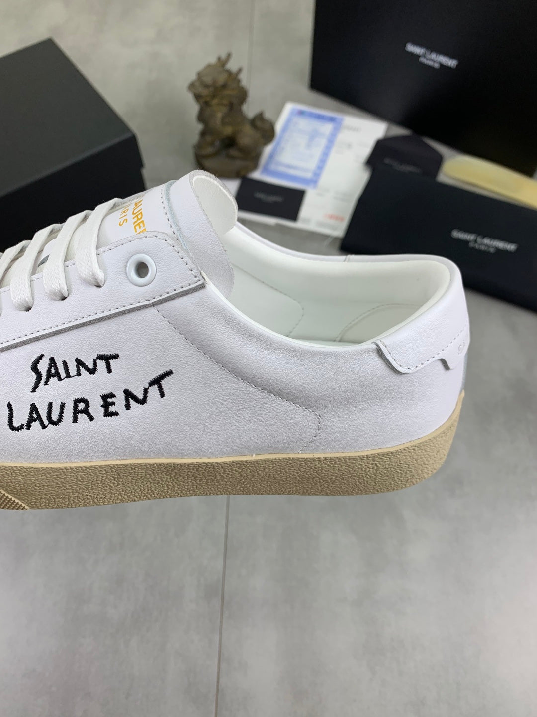 White YSL unisex sneaker with side logo, gum sole, lace-up front close view