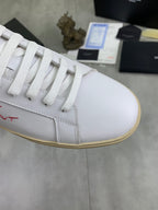 YSL unisex sneakers close-up, white leather with lace eyelets and red logo stitching