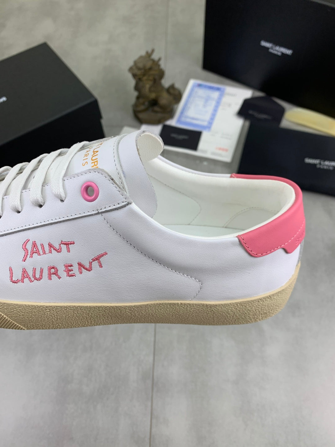 YSL unisex sneakers close-up, white leather side with pink heel panel and stitched logo