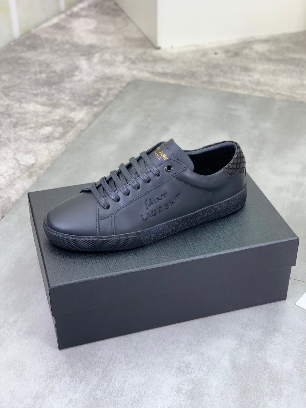 YSL leather lace-up sneakers in dark gray with low-profile rubber sole.