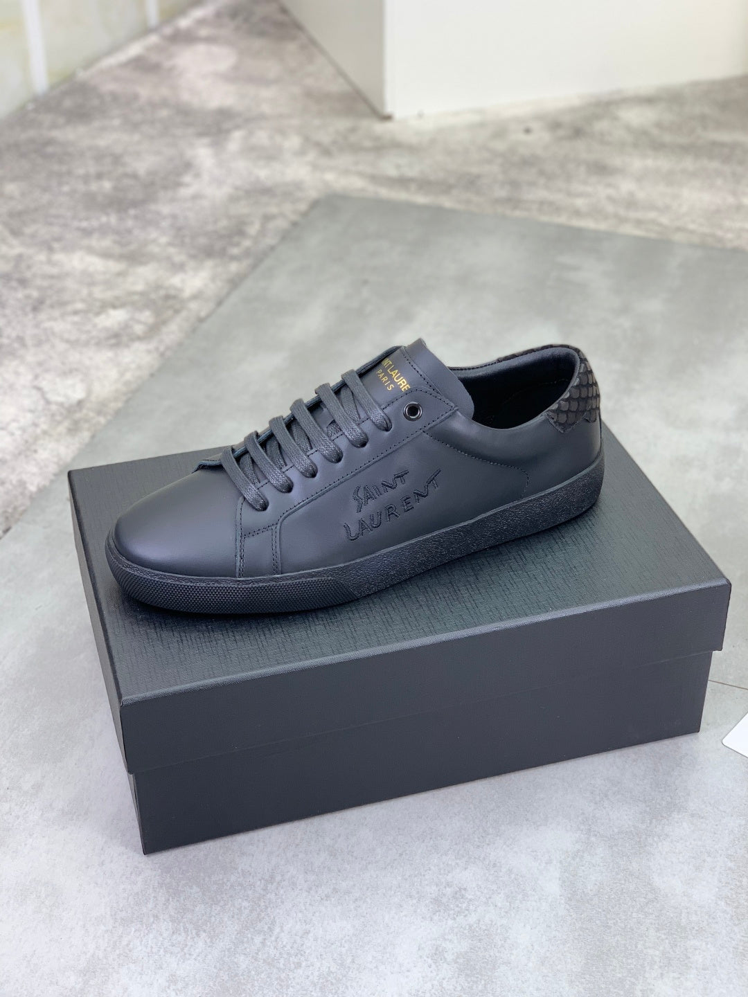 YSL leather lace-up sneakers in dark gray with low-profile rubber sole.