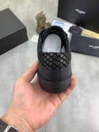 Heel view of dark leather lace-up YSL sneakers with textured upper panel.