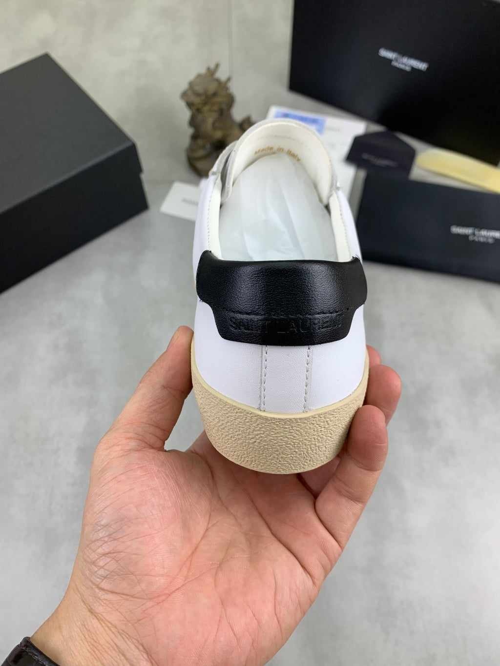 Saint Laurent unisex sneaker heel view, white upper with black strap and beige sole