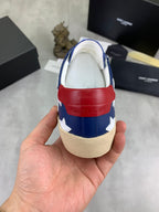 Back view of blue low-top sneakers with red heel tab and beige sole