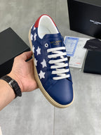 Blue low-top sneakers with white star panels, white laces, beige rubber sole