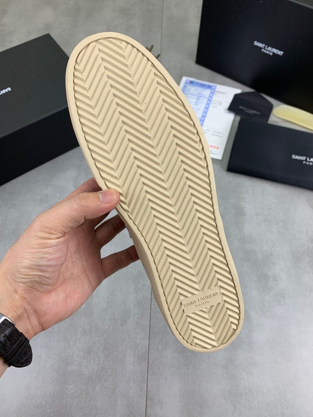 Beige rubber outsole with herringbone tread from blue low-top sneakers