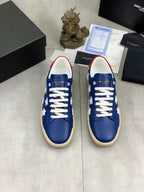 Pair of blue low-top sneakers with white stars and white laces, beige soles
