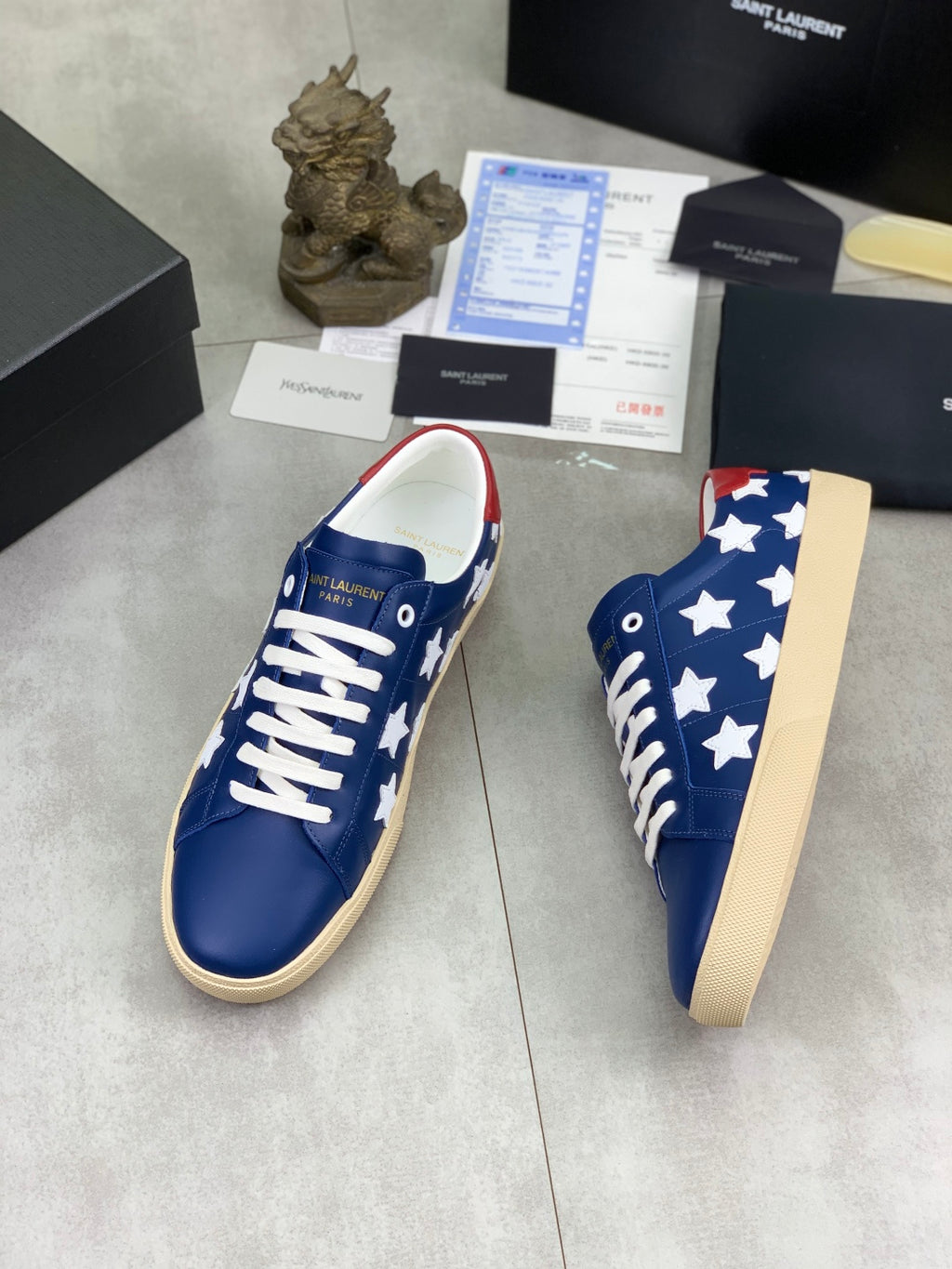 Blue low-top sneakers with white star pattern and white laces, beige platform sole