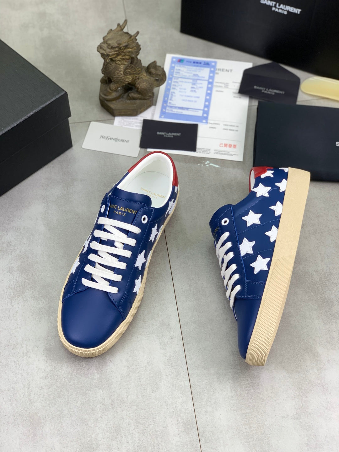 Blue low-top sneakers with white star pattern and white laces, beige platform sole