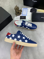 Blue low-top sneakers with white stars and white laces, beige sole, red heel tab