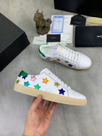 Unisex low-top sneakers laid out: multicolor stars on white with green inner trim