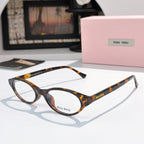 MiuMiu eyeglasses with dark tortoiseshell frame and clear lenses, round oval front view