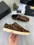YSL unisex leopard-print sneakers with white rubber soles, one held in hand