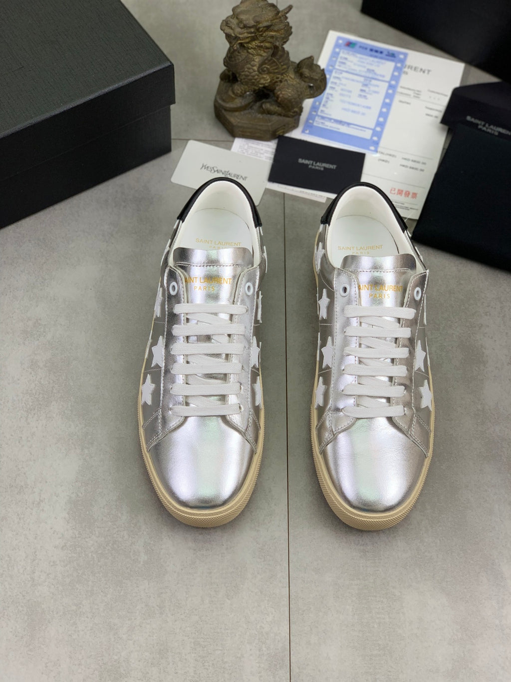 YSL unisex low-top sneakers pair, silver uppers with white star pattern, white laces, gum sole