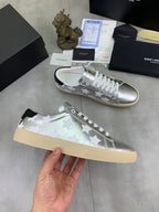 YSL unisex low-top sneakers held in hand, silver with white stars, white laces, gum sole