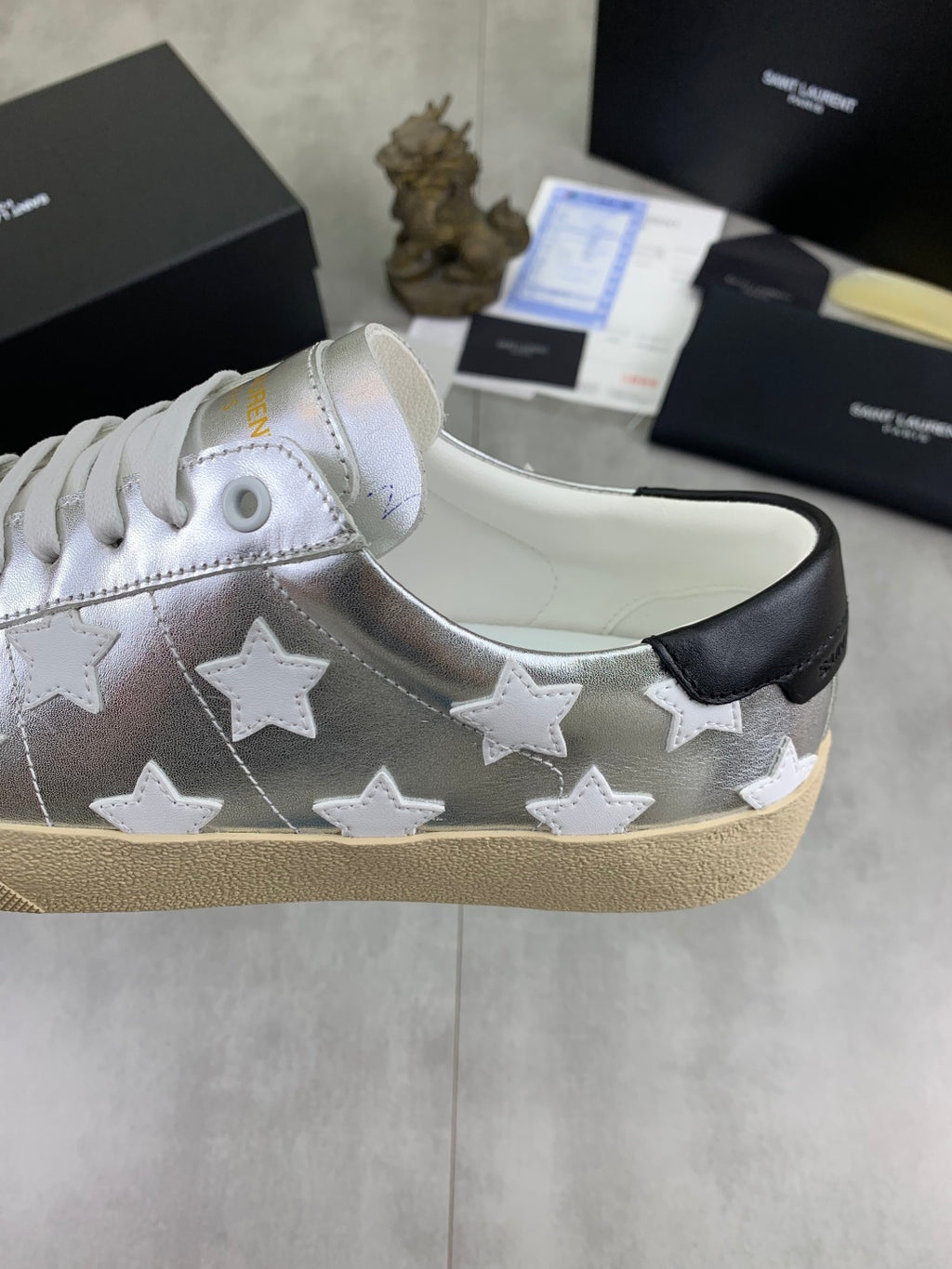 YSL unisex low-top sneakers side view, silver with white stars, black heel tab, gum sole