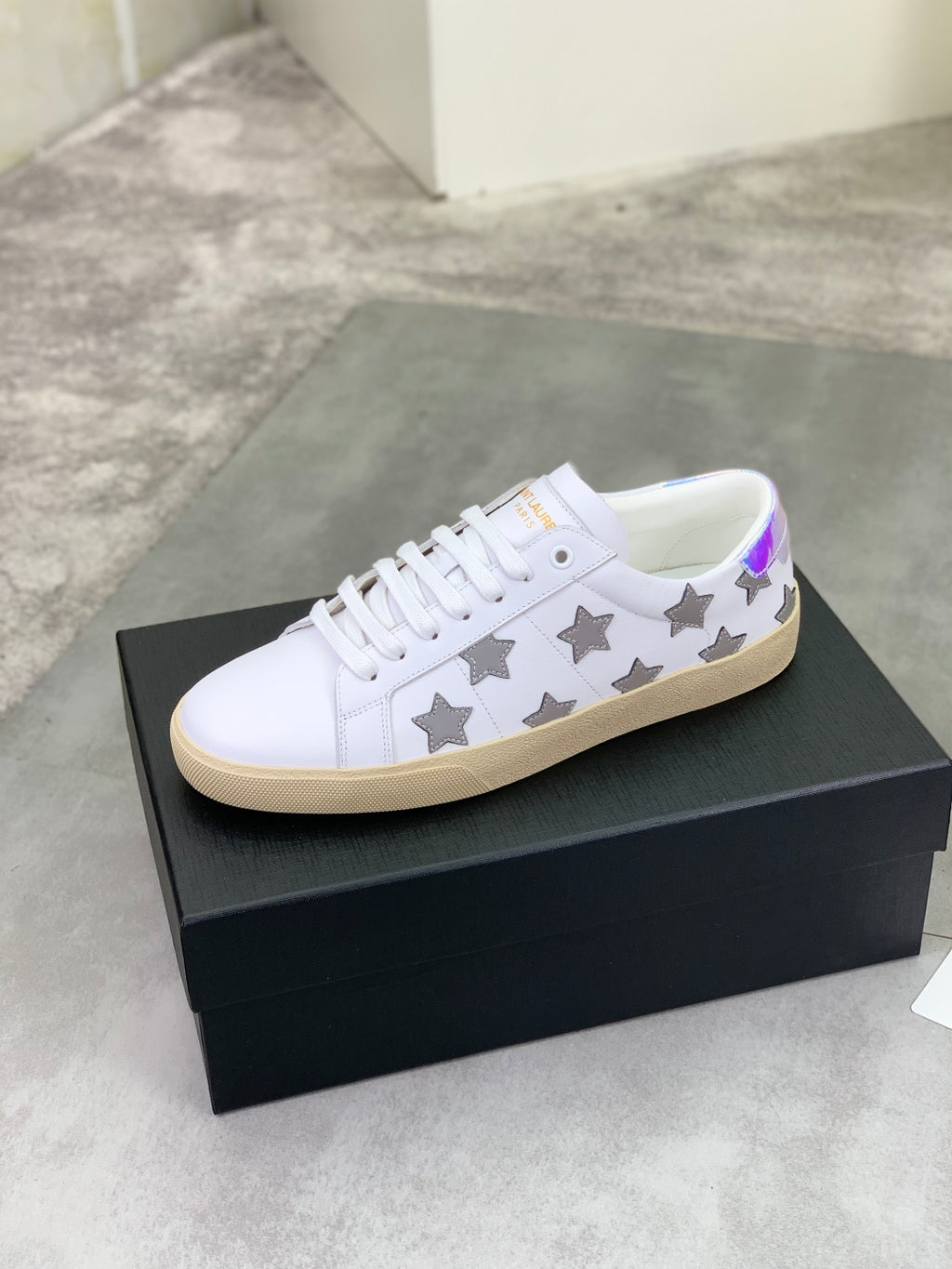 Unisex white low-top sneakers with gray stars, white laces, and beige sole