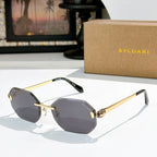 Gold-rimmed sunglasses with gray-tinted lenses and slim angular temples