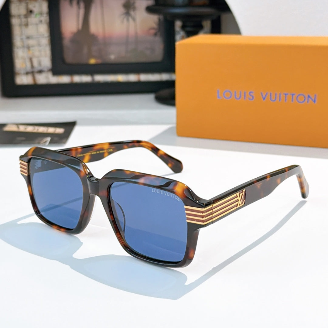 Designer sunglasses, tortoiseshell frames with blue gradient lenses and gold striped temple accents.