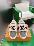 Pair of gray low-top sneakers with cream sherpa lining and black logo patches