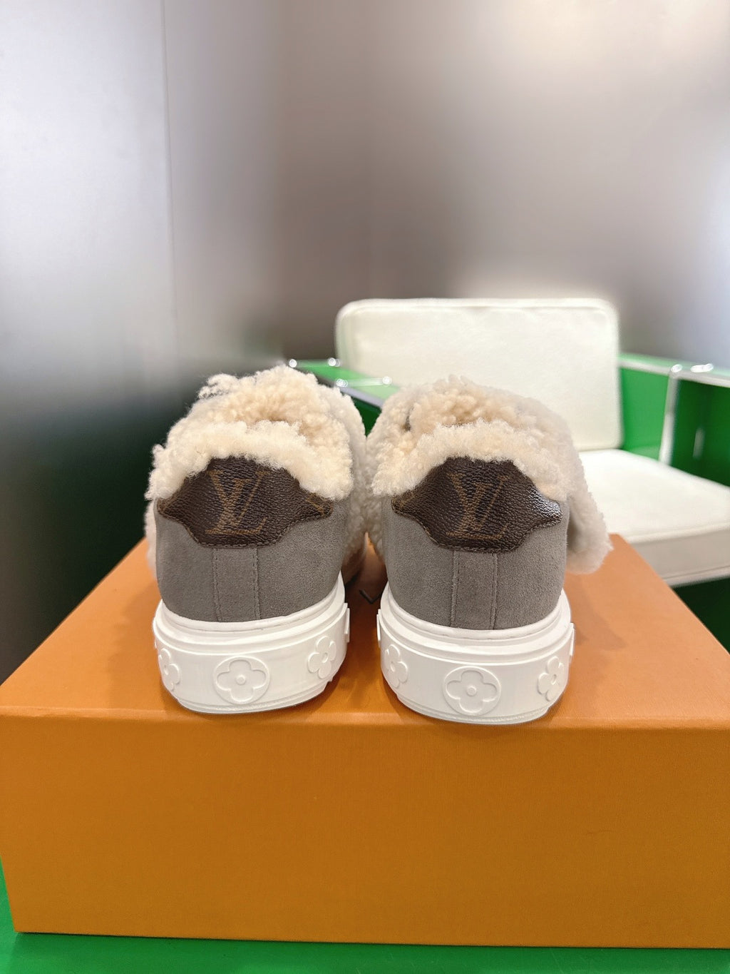 Back view of gray sneakers with cream sherpa lining and brown heel logo