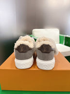 Back view of gray sneakers with cream sherpa lining and brown heel logo