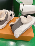 Close-up of two gray sneakers with cream sherpa straps and black star logo