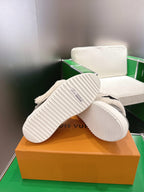 Bottom view of gray low-top sneakers showing white rubber outsole tread