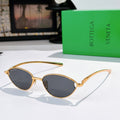 Bottega Veneta sunglasses with gold frame and dark tinted oval lenses