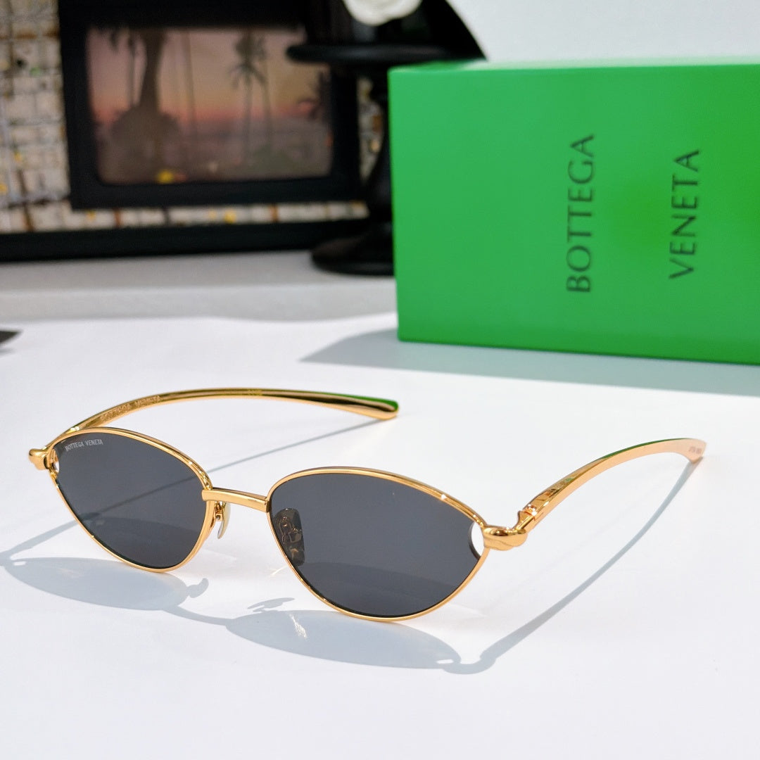 Bottega Veneta sunglasses with gold frame and dark tinted oval lenses