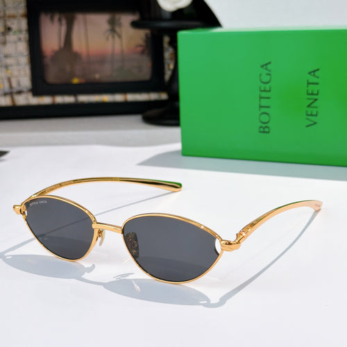 Bottega Veneta sunglasses with gold frame and dark tinted oval lenses