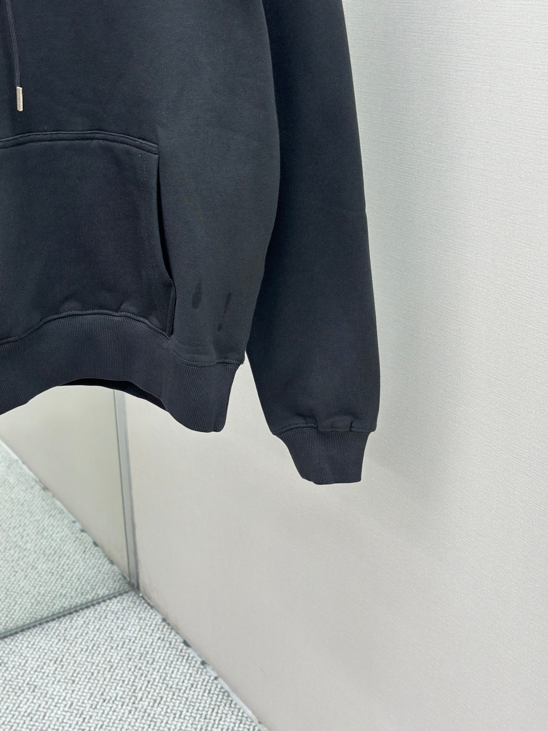 Dark blue hoodie close-up of lower front and kangaroo pocket, ribbed cuffs