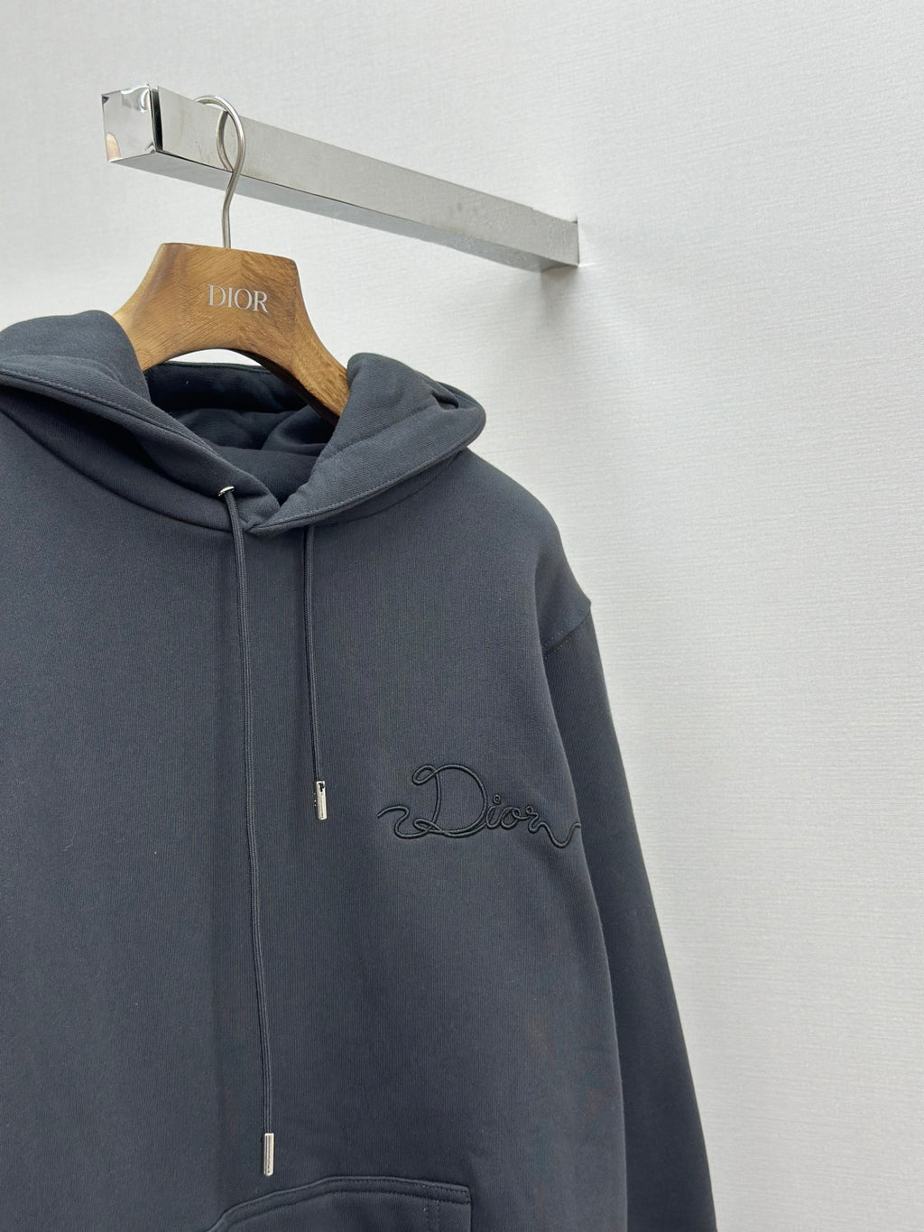 Dark blue pullover hoodie with hood, drawstring, and embroidered logo on chest