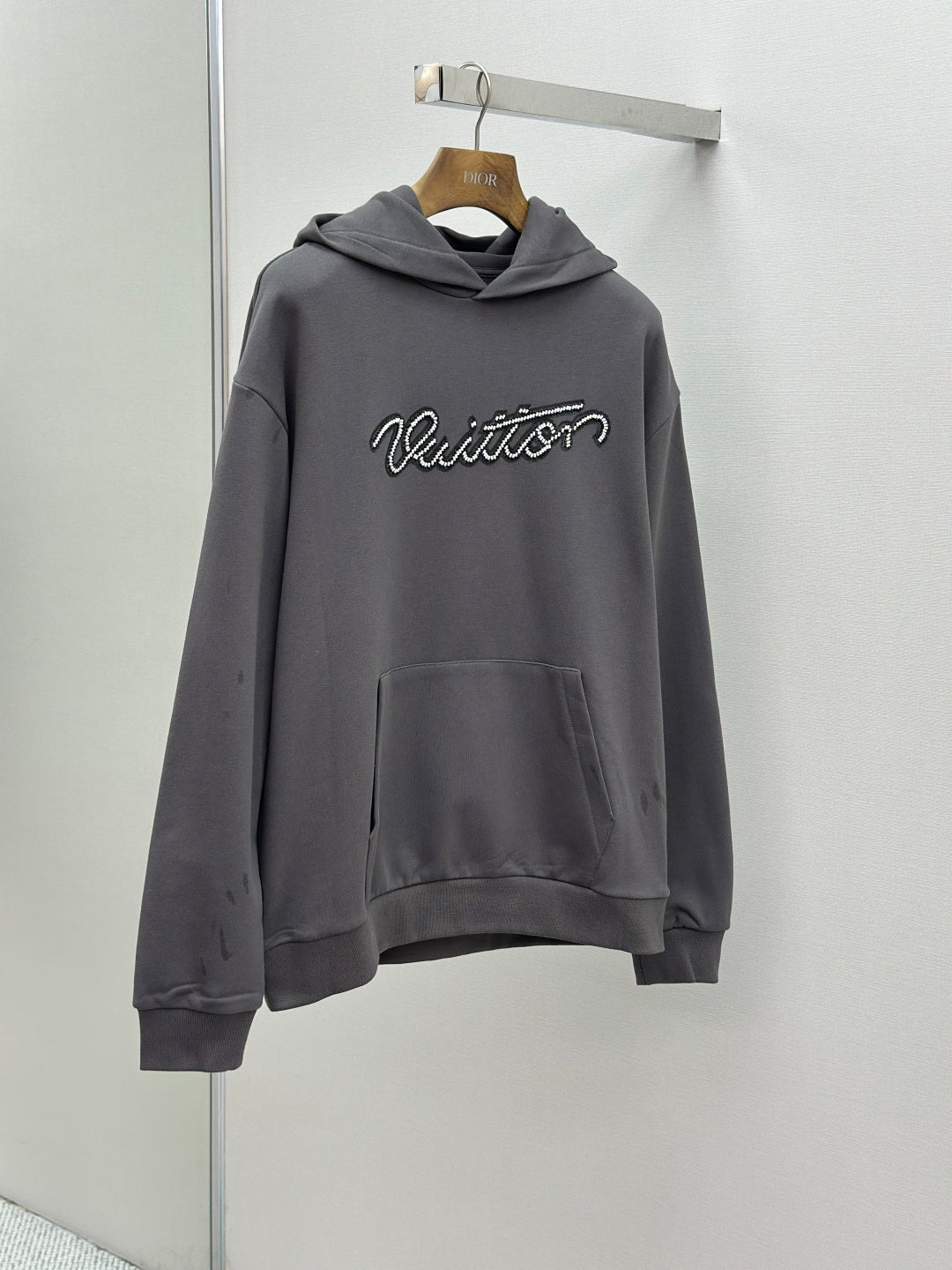 Dark gray long-sleeve hoodie with hood, front pocket, and Louis Vuitton logo