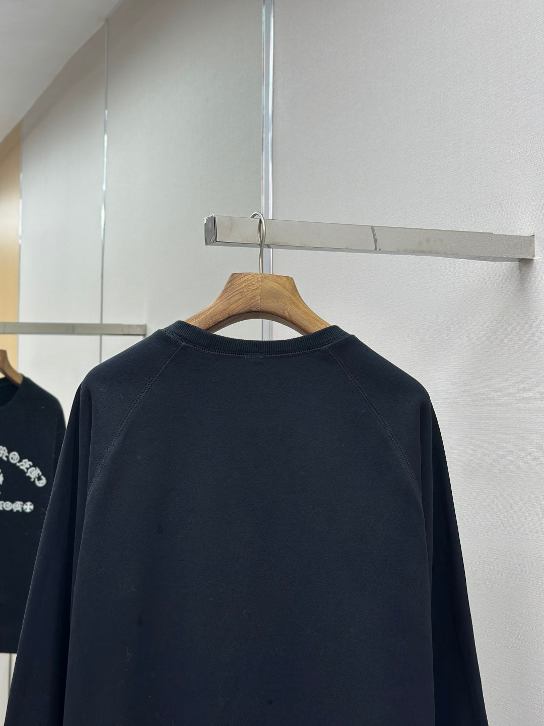 Navy crewneck long-sleeve sweatshirt back view on hanger
