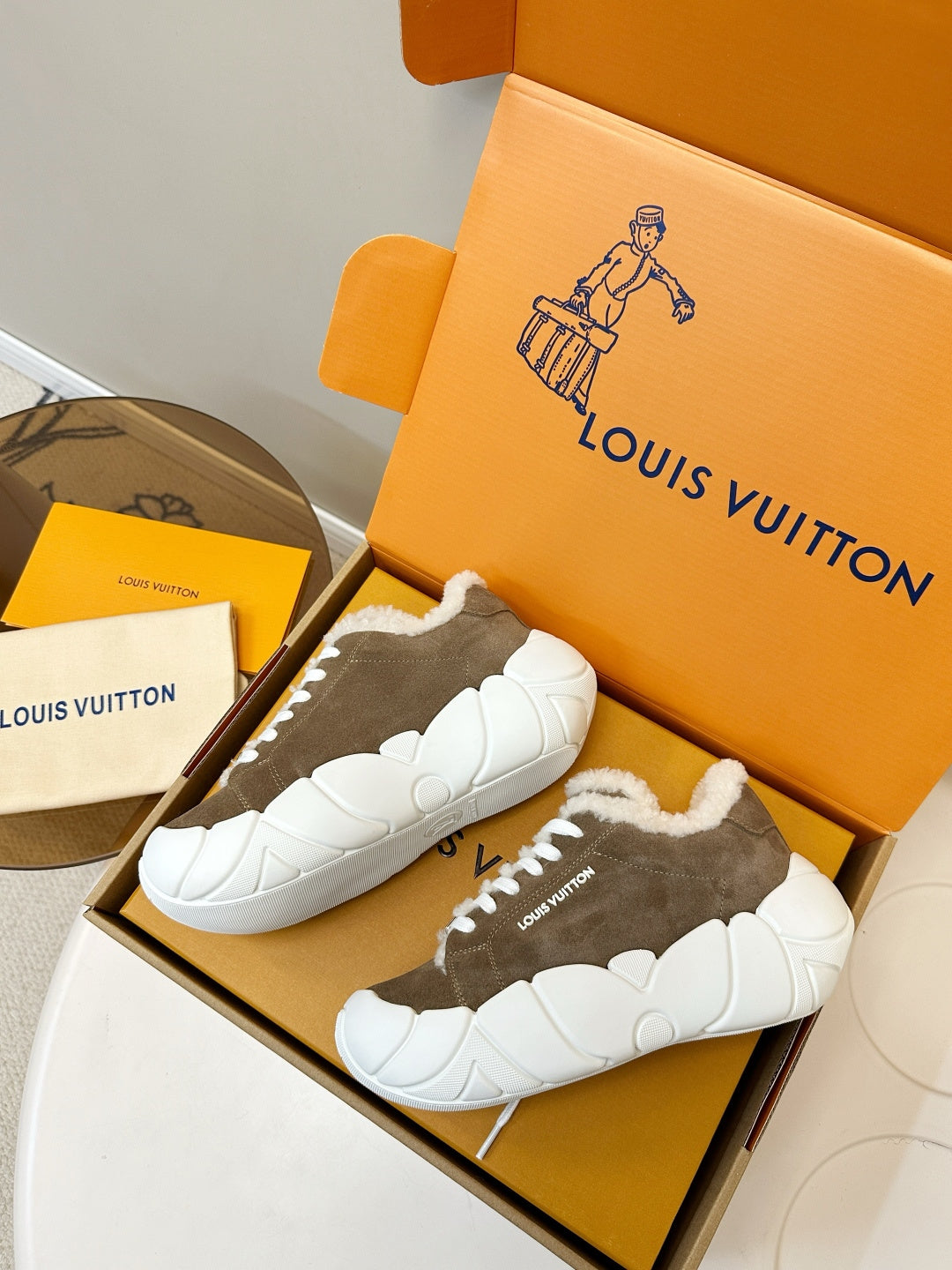 Pair of brown sneakers with white plush lining and chunky white soles