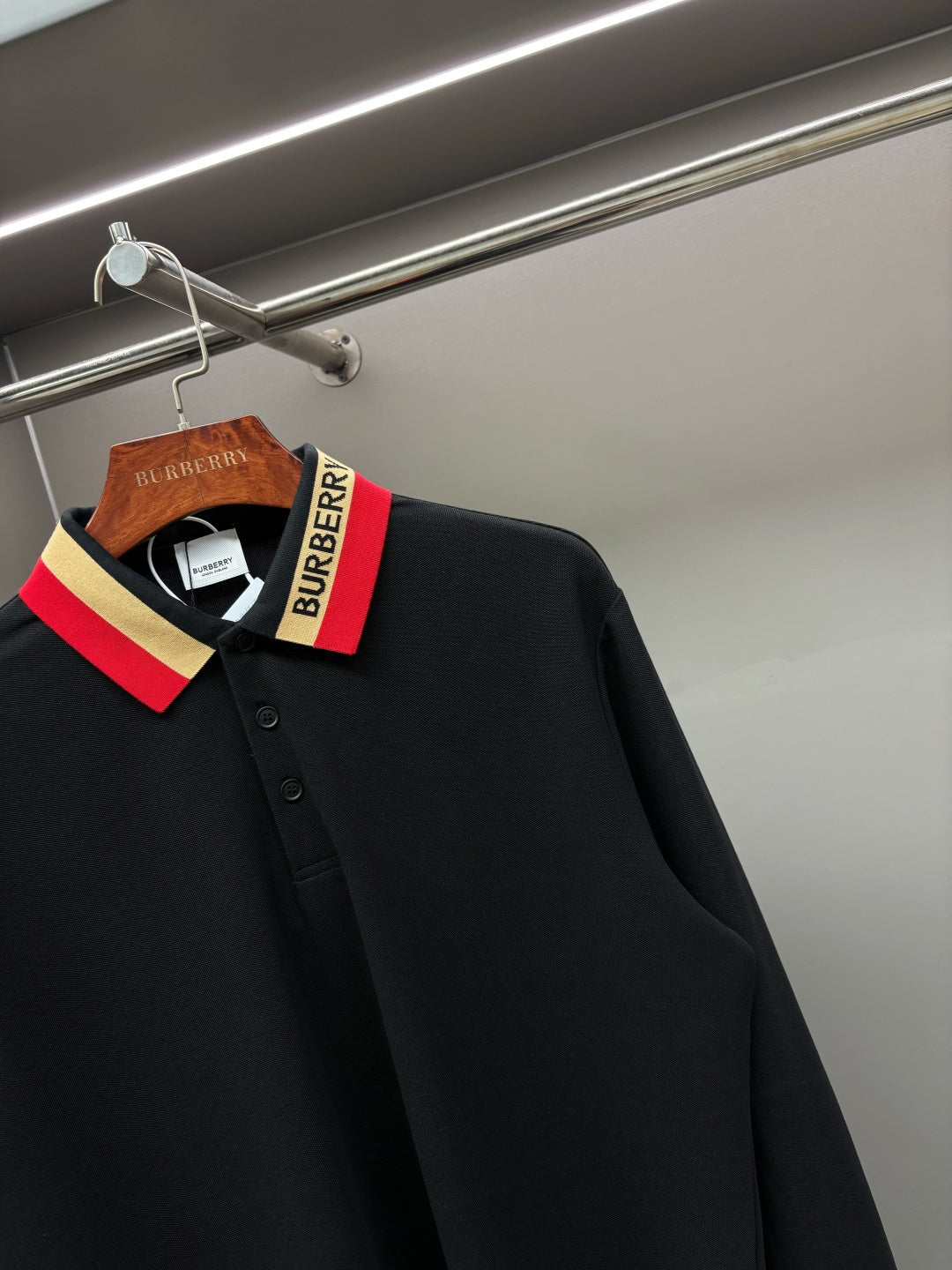 Black long-sleeve polo shirt collar with Burberry logo tag and striped trim