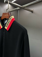 Black long-sleeve polo shirt with striped collar and button placket